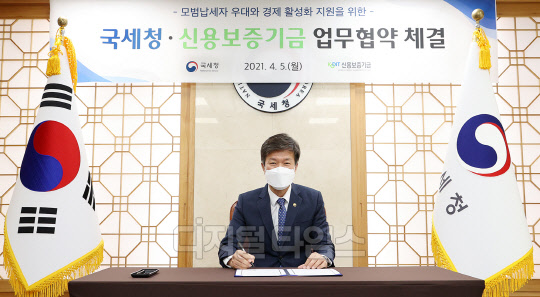 김대지 국세청장이 5일 신용보증기금과 모범납세자 우대와 신용보증기금의 신용보증 업무 지원을 위한 업무협약서에 서명하고 있다. 국세청 제공